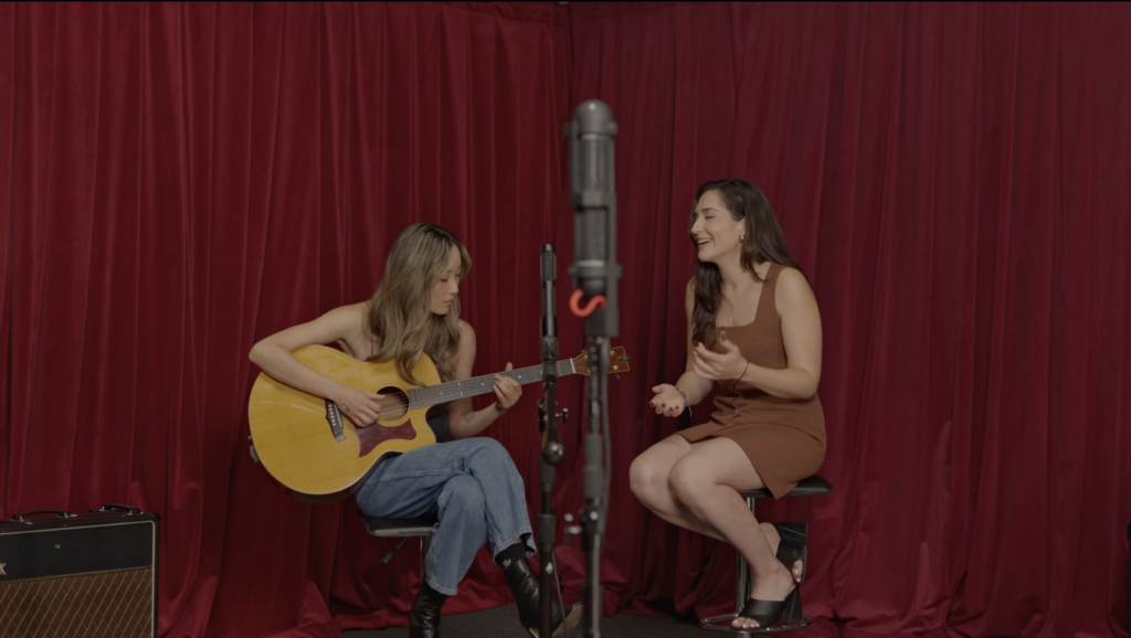 Carly and Nia, singer-songwriters - perform in front of a red backdrop with the AEA R88 and N28 microphones
